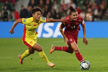 Wang Shuan y Veje corren tras el balón durante el choque entre China y Dinamarca.