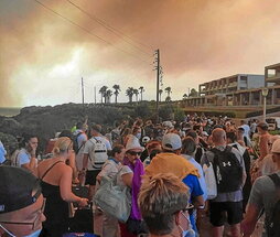 Turistas observan el humo de los incendios en Rodas.