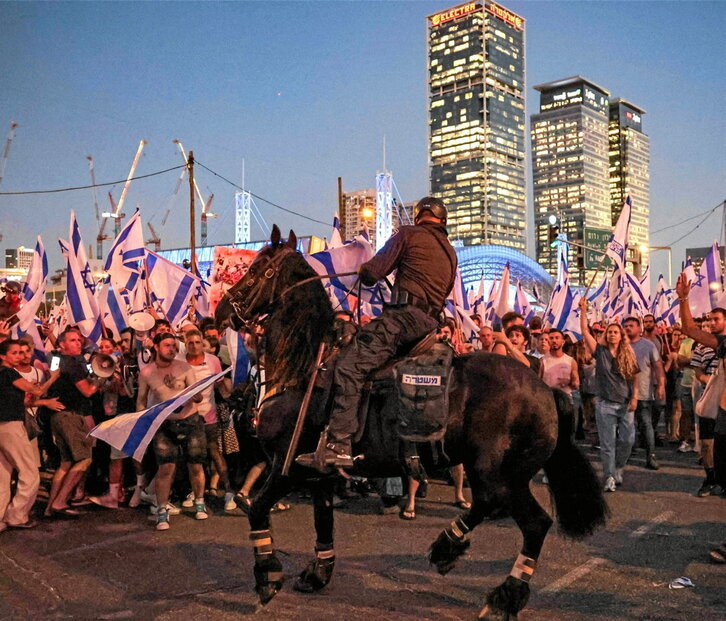 Policías a caballo tratan de contener a los manifestantes en Tel Aviv.