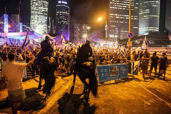 Policías a caballo intentan contener a los manifestantes en Tel Aviv.