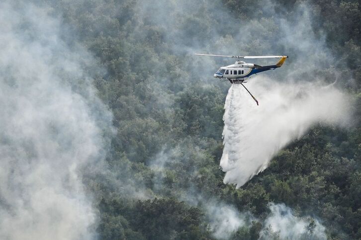 Un helicóptero sobrevuela uno de los incendios declarados en la isla griega de Corfú.