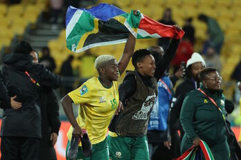 Holweni y Kgadiete ondean la bandera sudafricana para celebrar el triunfo.