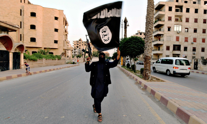 Un miembro del ISIS sostiene una bandera de la organización en Raqa, Siria, en una imagen de archivo. 