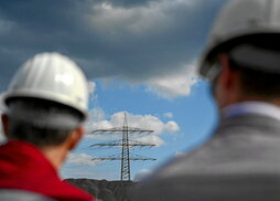 Dos empleados frente una torre eléctrica en una factoría de Duisburgo, Alemania.  AFP