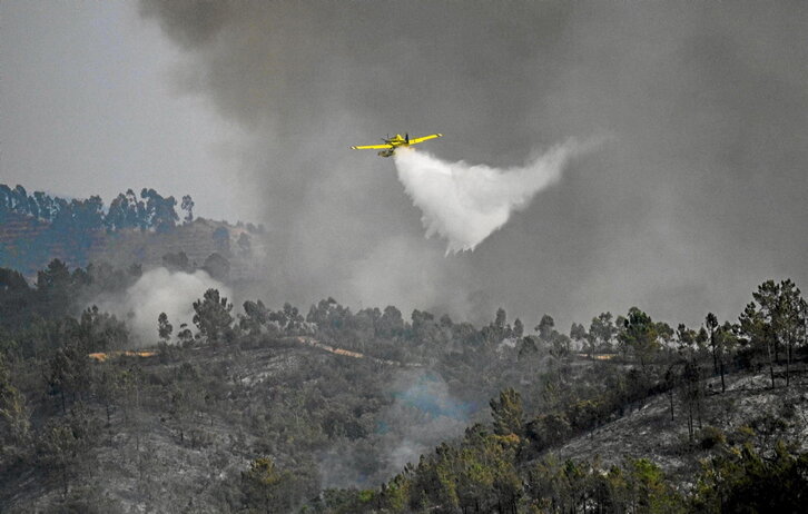 Una avioneta lanza agua sobre el incendio de Odemira, al sur de Portugal.