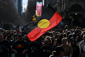 Una persona enarbola una bandera aborigen de Australia durante una marcha en Melbourne el 7 de julio. 