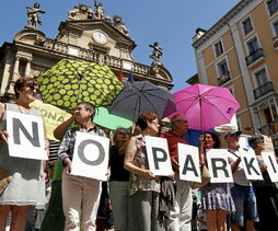 A la izquierda, protesta contra el parking de la plaza de la Cruz de Iruñea. Arriba, operario podando árboles a los pies de la Torre Iberdrola de Bilbo.