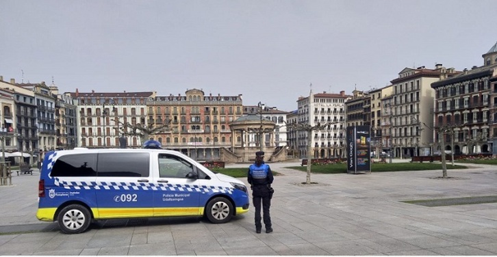 Un vehículo y una agente de la Policía Municipal de Iruñea.