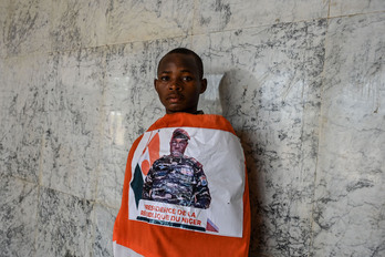 Un joven nigerino, con una bandera de su país que luce el retrato de Abdourahmane Tchiani, líder de la junta militar golpista. 