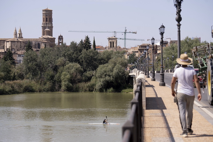 Un hombre cruza el puente del Ebro en Tutera un día de calor.