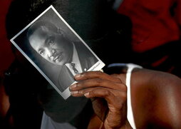 60. urteurreneko martxan, parte-hartzaile bat, Martin Luther Kingen argazkia eskuan duela.