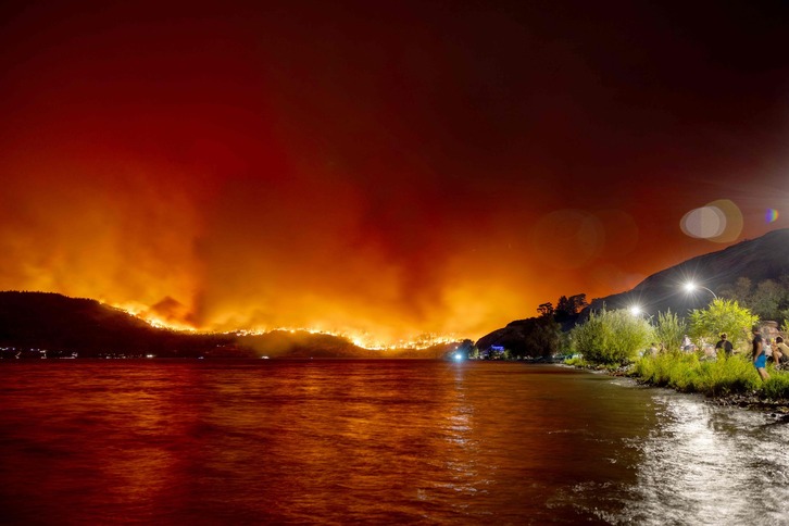 Habitantes de Kelowna (British Columbia) contemplan la voracidad del fuego en esta imagen del 17 de agosto.