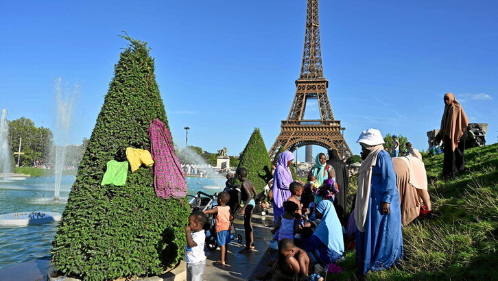 Personas de todas las edades se refrescan en las fuentes aledañas a la Torre Eiffel de París durante la larga ola de calor que afectó al sur de Europa hace dos semanas.