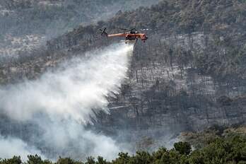 Un helicóptero trabaja las labores de extinción del incendio.
