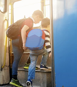 Dos escolares suben a un autobús.