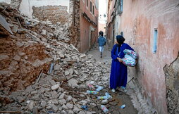 Una mujer observa los escombros de una vivienda destruida en Marrakech.