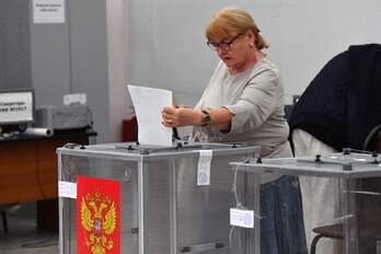 Una mujer deposita su papeleta en la urna en un colegio electoral de Moscú.