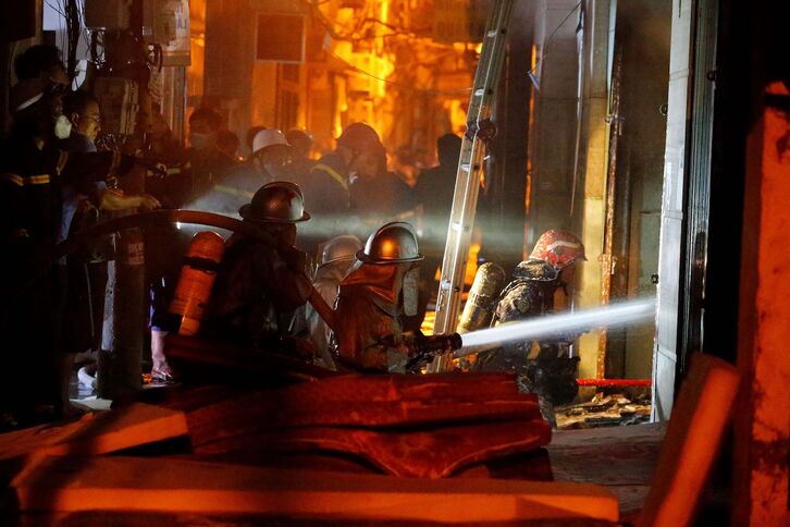 Equipos de bomberos tratando de sofocar las llamas en Hanoi..