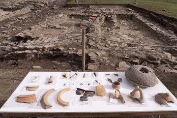 Algunos de los restos hallados en las excavaciones situados ante la nueva zona excavada, donde se aprecian, a la izquierda, las escaleras de una vivienda.