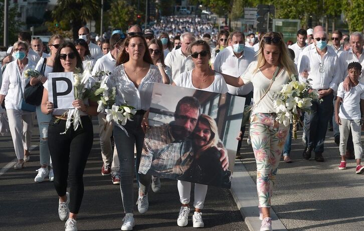 Véronique Monguillot, apoyada por sus tres hijas, porta el retrato de su marido en la marcha blanca que recorrió el 8 de julio de 2020 las calles de Baiona.