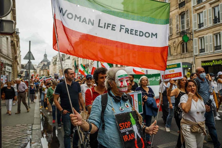 Una manifestante porta una bandera con los colores de la bandera iraní durante una protesta contra el Gobierno en la plaza de la Bastilla de París.