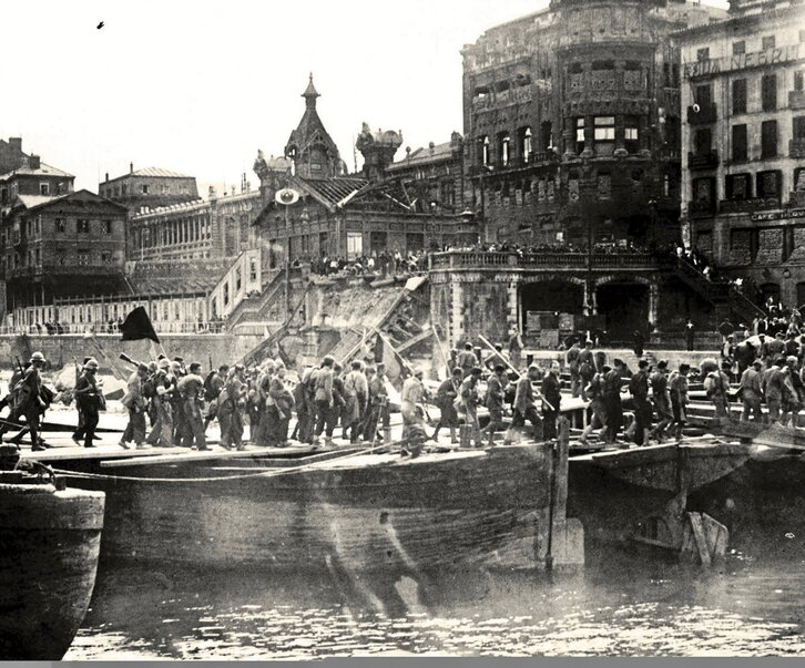 Tropas franquistas entrando a Bilbo y cruzando la ría por un puente improvisado a la altura del Arenal.