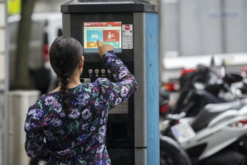 Una mujer ante una máquina de la OTA en una calle de Bilbo.