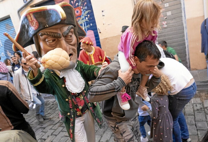 Caravinagre dándole su merecido a un aita y, a la derecha, los dantzaris de Duguna recorriendo la calles del centro de Iruñea.