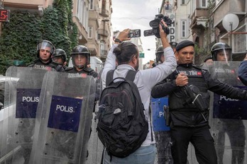 Policías turcos impiden el paso de un fotógrafo a la sede del partido HDP en el distrito de Beyoglu, en Estambul, tras las detenciones de casi 70 personas.