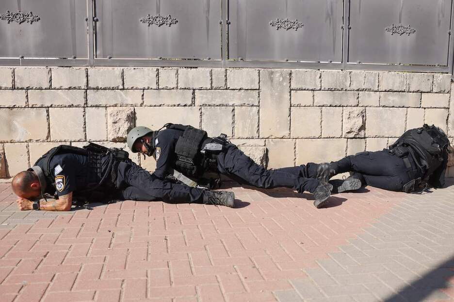 Soldados israelíes se protegen en una calle de Ashkelon.