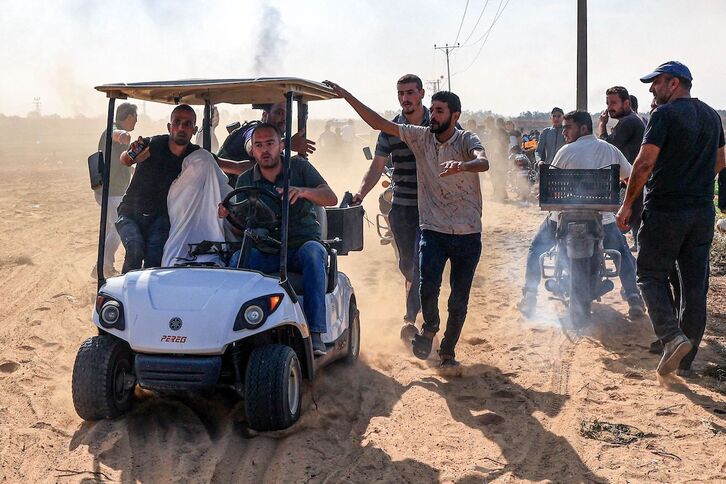 Palestinos transportan en Khan Yunis a un israelí presuntamente capturado.