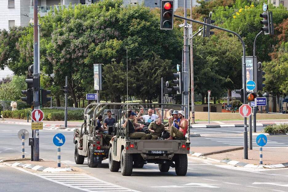 Reservistas de ejercito israelí son transportados en vehículos militares para unirse a su base militar al sur de Tel Aviv.