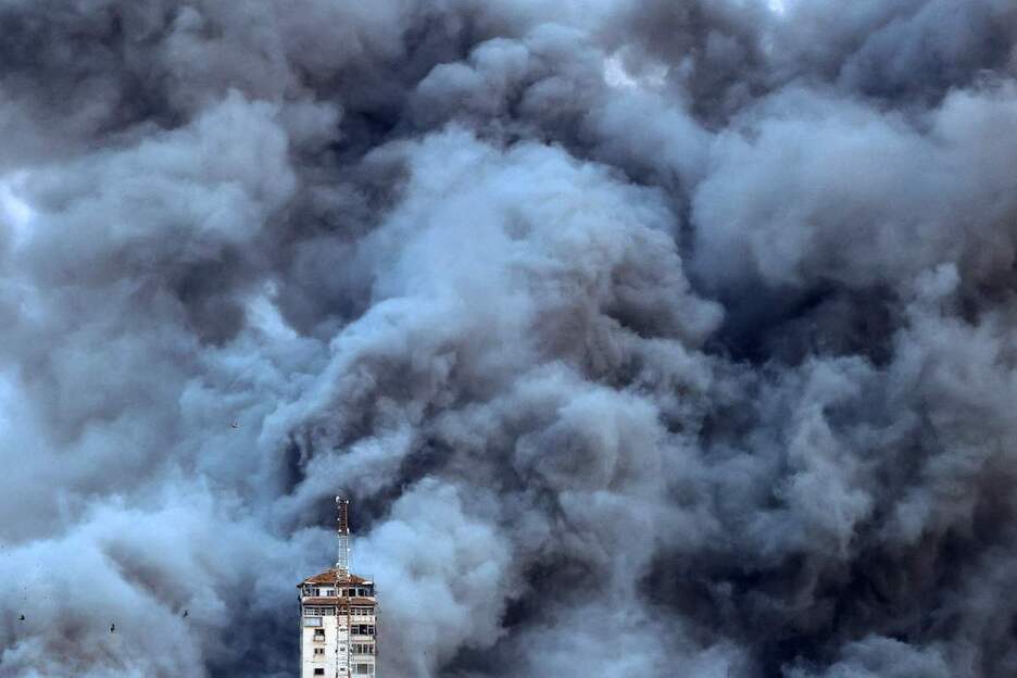 Un edificio de Gaza envuelto en humo por las bombas y misiles israelíes.