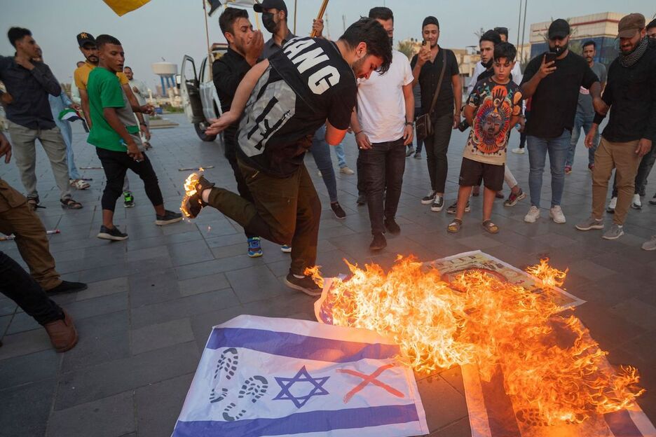 Manifestantes iraquíes queman banderas israelíes durante una manifestación celebrada en el centro de Bagdad.