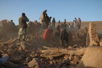Afganos buscan entre los escombros.
