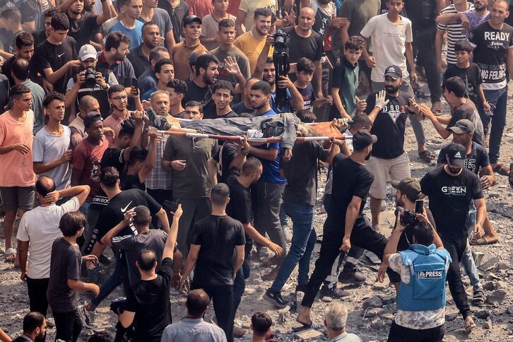 Palestinos trasladan un cadáver tras un ataque israelí a la mezquita Sousi de Gaza.