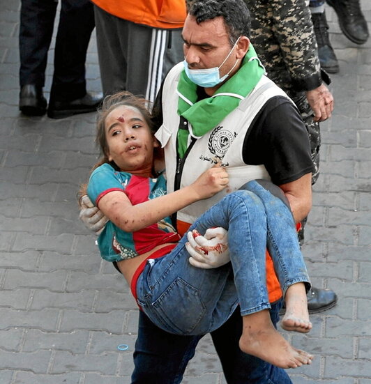Un sanitario lleva una niña herida al hospital Al-Shifa.