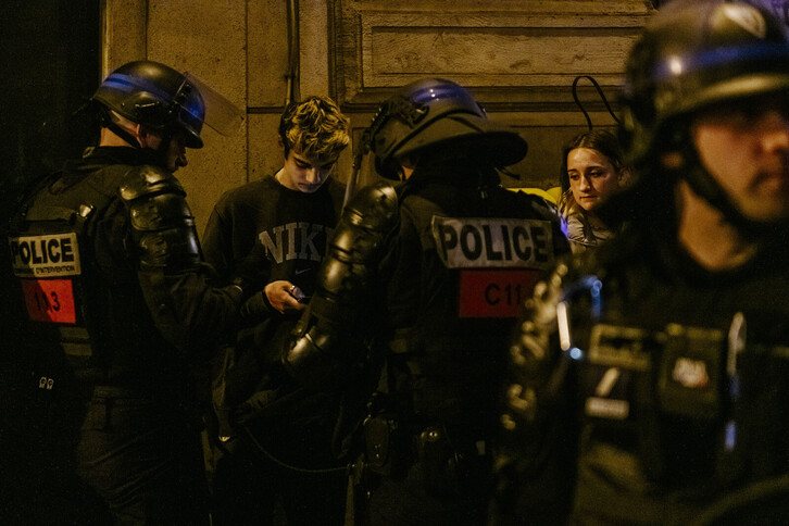 Poliziak, gazte bat identifikatzen Parisen. 