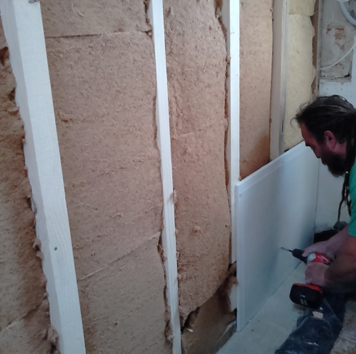 Trabajador aislar la pared de una habitación con aislamiento