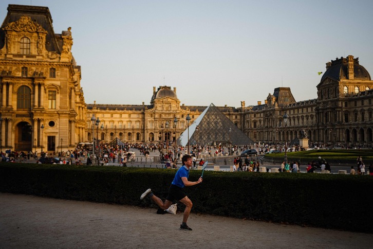 Un hombre juega al badminton en los Jardines de las Tullerías, con el Louvre de fondo. La imagen es del día 7, muy distinta de la de hoy.