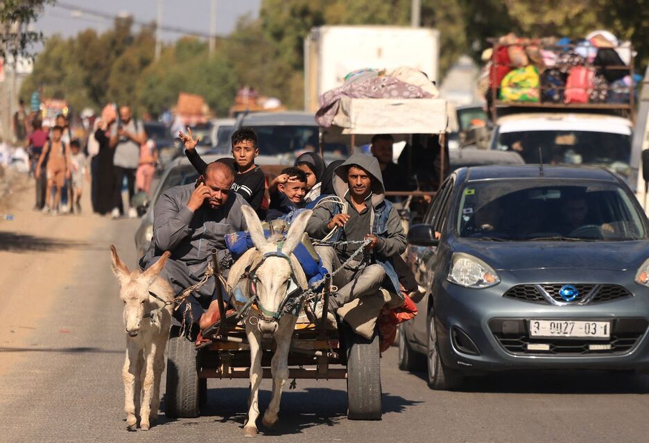 Una familia y cientos de palestinos con sus pertenencias huyen en un carro tirado por un burro tras la advertencia del ejército israelí de abandonar sus hogares y desplazarse hacia el sur antes de la ofensiva terrestre prevista.
