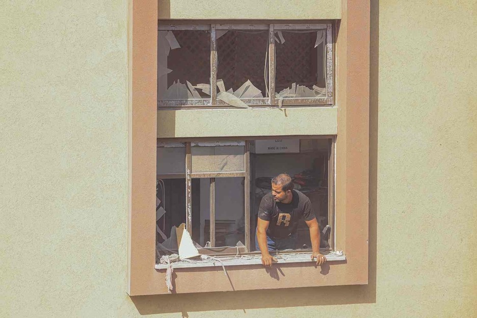 Un palestino mira por la ventana de un edificio dañado tras los ataques israelíes en Jan Yunis.