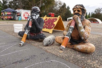 Dos figuras de indígenas australianos con didgeridoos en la Aborigenal Tent Embassy, una acampada que reclama derechos para la población originaria ante el Parlamento de Canberra.