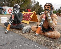 Estatuas de indígenas acompañan una protesta.