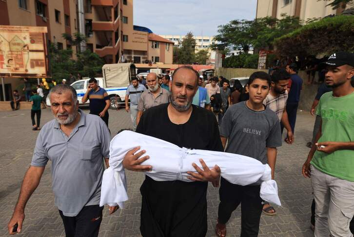 Un hombre porta el cuerpo sin vida de un menor en la Franja de Gaza.