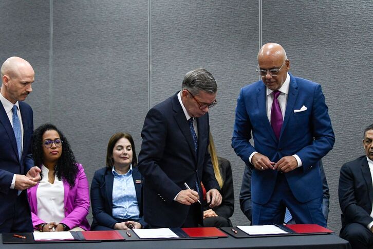 El jefe negociador de la oposición, Gerardo Blyde, y Jorge Rodríguez, presidente de la Asamblea Nacional de Venezuela, firman el acuerdo en Barbados. 