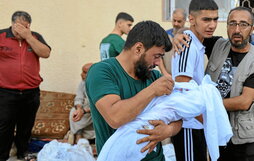 Un padre se despide de su bebé muerto en los bombardeos israelíes a Gaza.