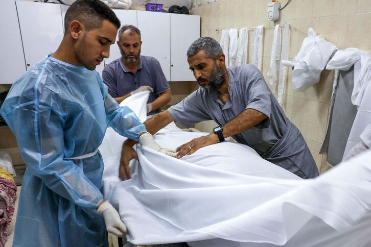 Médicos del hospital Najjer de Rafah, al sur de la Franja de Gaza, cubren con sábanas el cuerpo de un herido en un bombardeo cerca del centro sanitario.