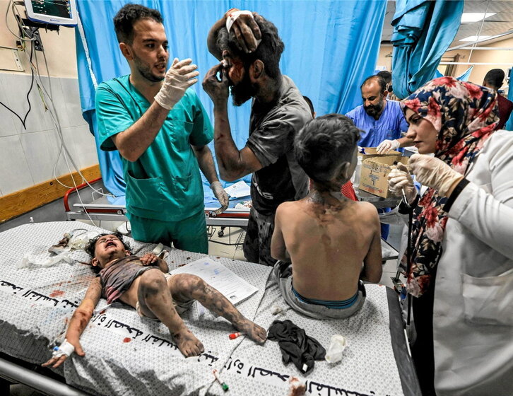 Un médico atiende a dos niños y un adulto heridos en un bombardeo en Jan Yunis.