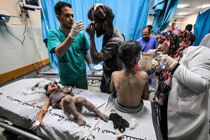 Un médico atiende a dos niños y un adulto heridos en un bombardeo en Jan Yunis.